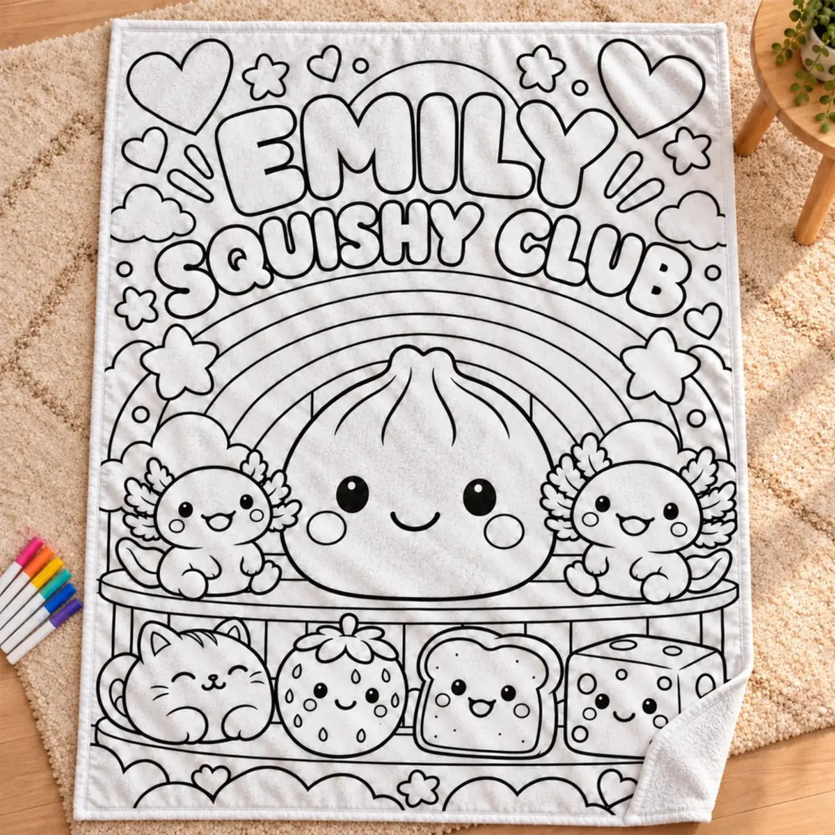 Flat view of the Squishy Club coloring blanket with outlined characters, a rainbow and the name Emily.
