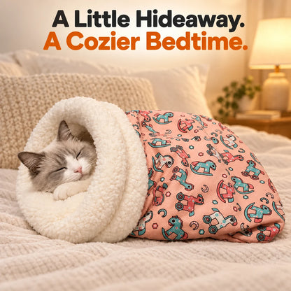 Cat inside pink elephant-print sleeping bag bed