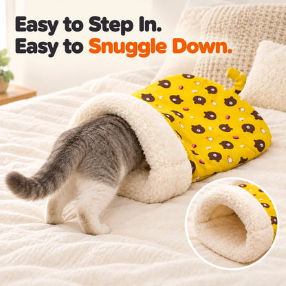 Cat entering yellow sleeping bag with plush-lined opening