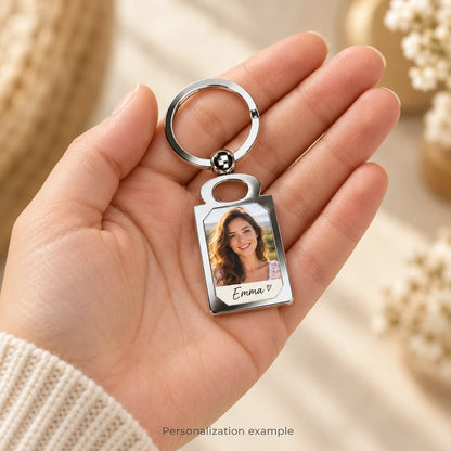 Illustrative personalized photo keychain handheld mockup with fictional portrait and sample name Emma