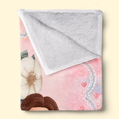 Folded floral monogram girl blanket showing white textured Sherpa backing