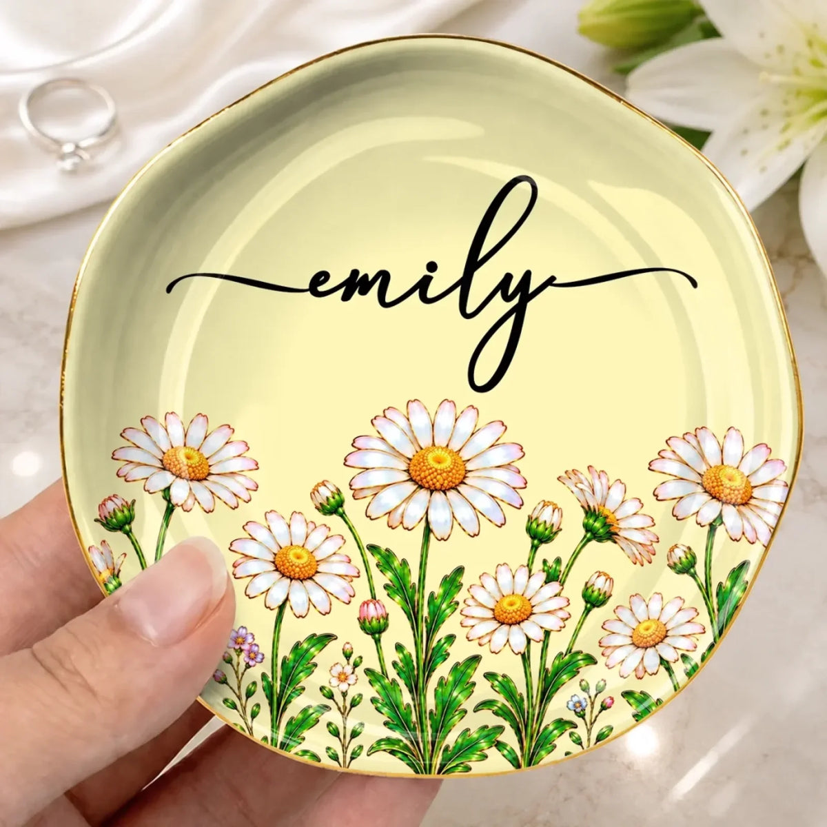 Pale yellow lace-circle jewelry dish with daisies and the name Emily, held in one hand
