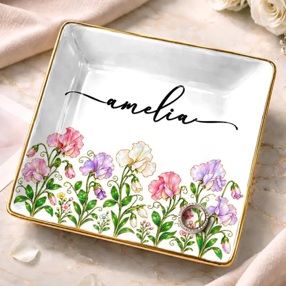Square white jewelry dish with pink and purple flowers, a gold-tone border and the name Amelia