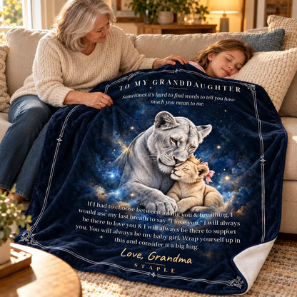 Grandmother gently tucking the navy lion blanket around her sleeping granddaughter on a sofa, with Love, Grandma message.