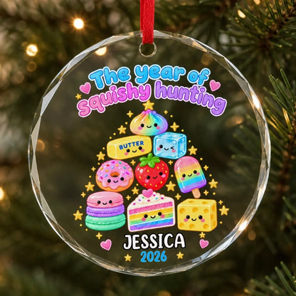 Glass ornament with smiling treat-tree artwork and example name Jessica, hanging on a Christmas tree