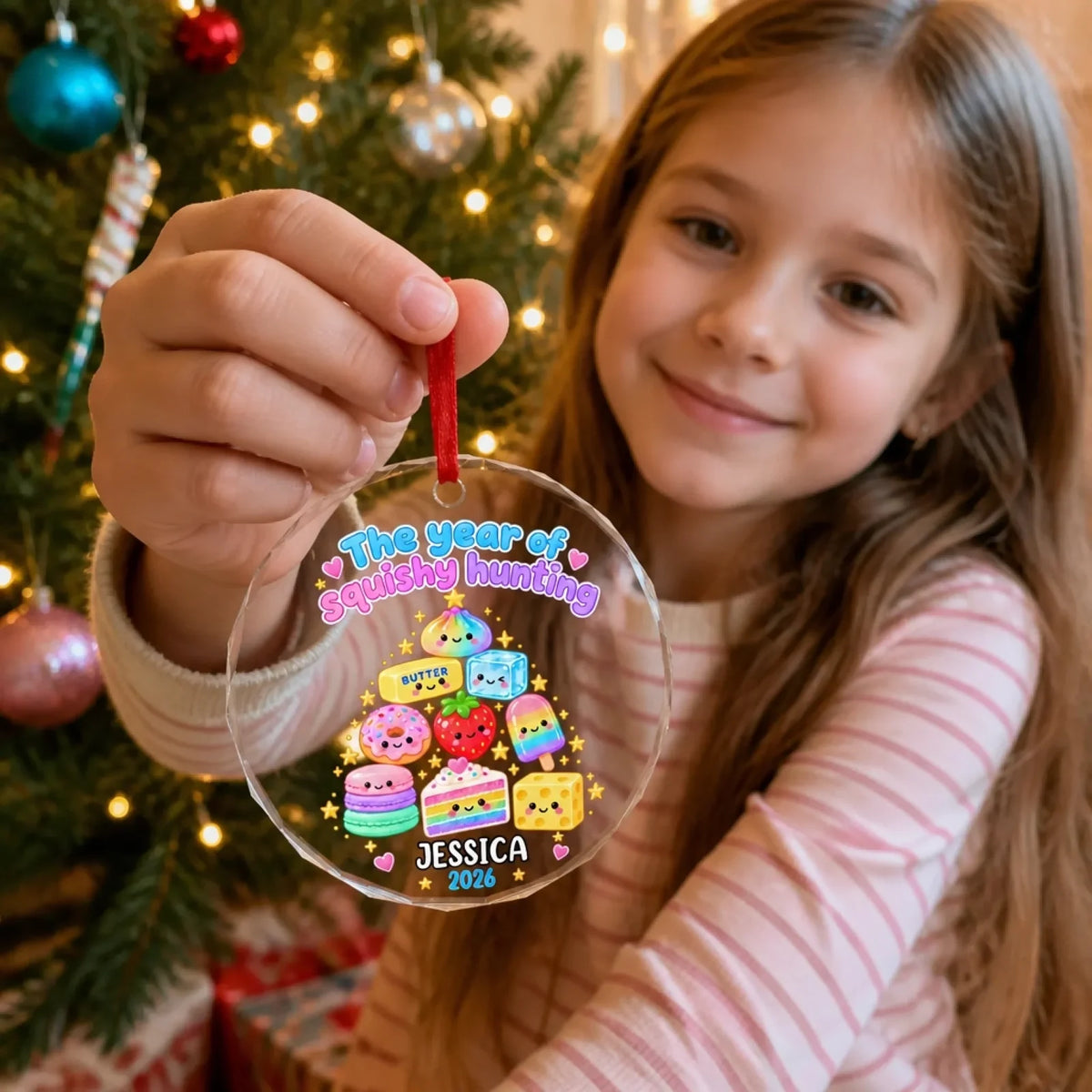 Held view of the glass treat-tree ornament with example name Jessica and year 2026