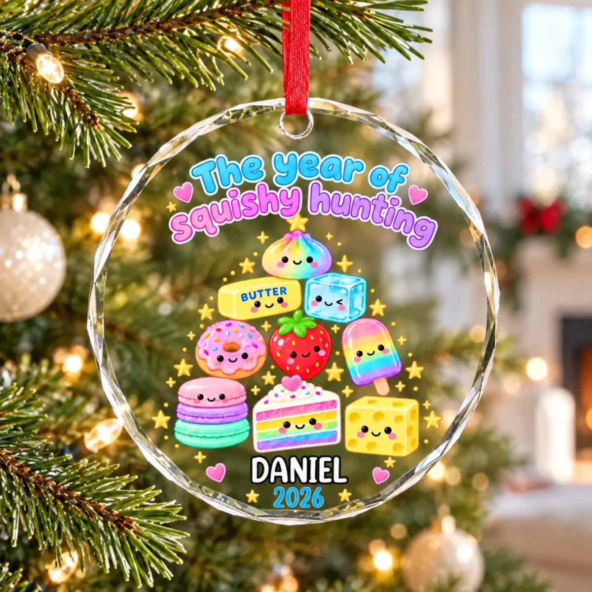 Glass treat-tree ornament with example name Daniel and year 2026 on a Christmas tree