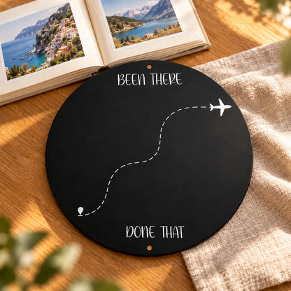 Bare circle Been There Done That travel magnet display board beside a family travel photo album