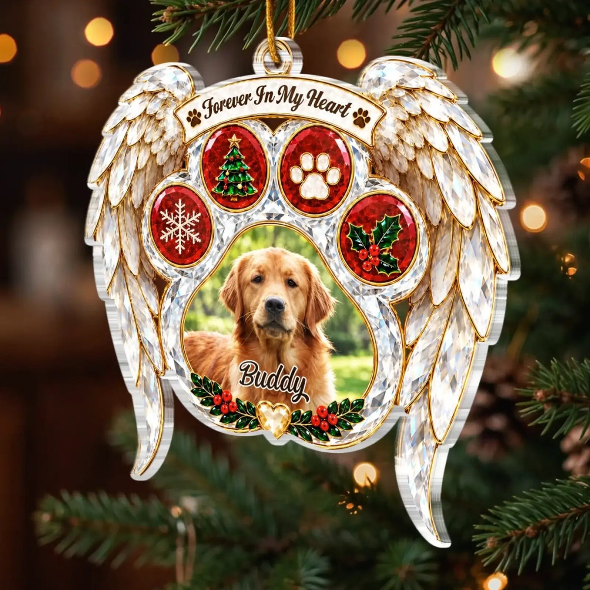 Angel wing pet memorial ornament with a dog photo, Buddy name and festive paw-print details among evergreen branches.