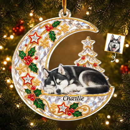 Crescent moon pet memorial ornament with a sleeping husky portrait, Charlie name, holly and Christmas tree, hanging on a tree.