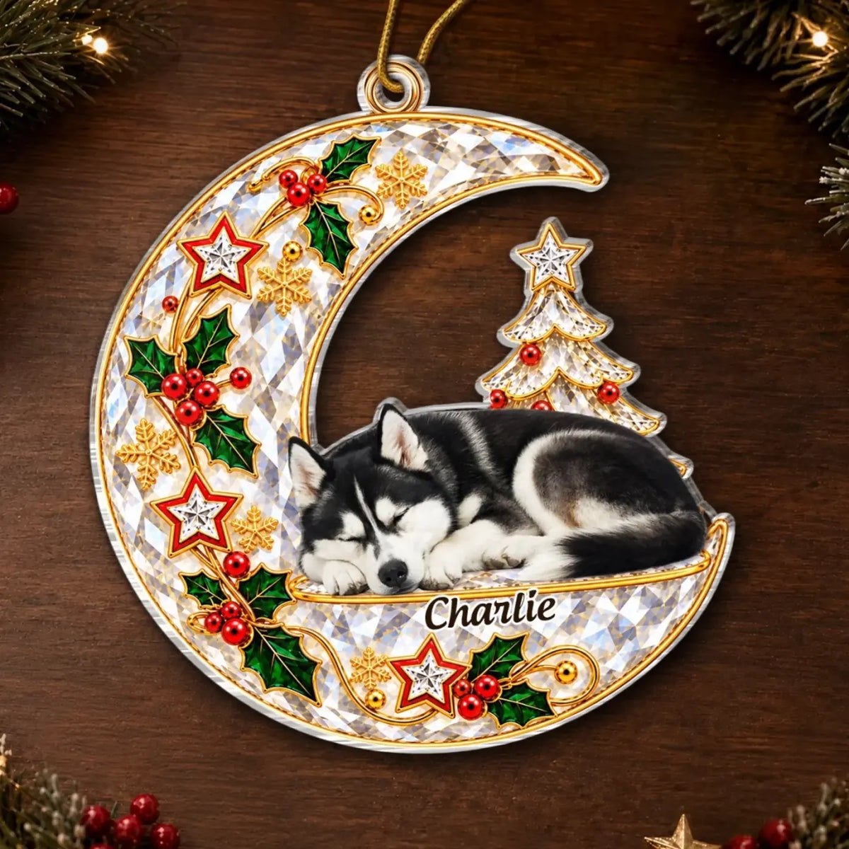 Crescent moon pet memorial ornament with a sleeping husky portrait, holly and stars on a wooden background.