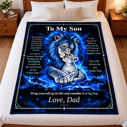 Illustrative bedroom mockup: To My Son lion blanket displayed full-size on a bed, showing the Original Blue artwork and Love, Dad signature.